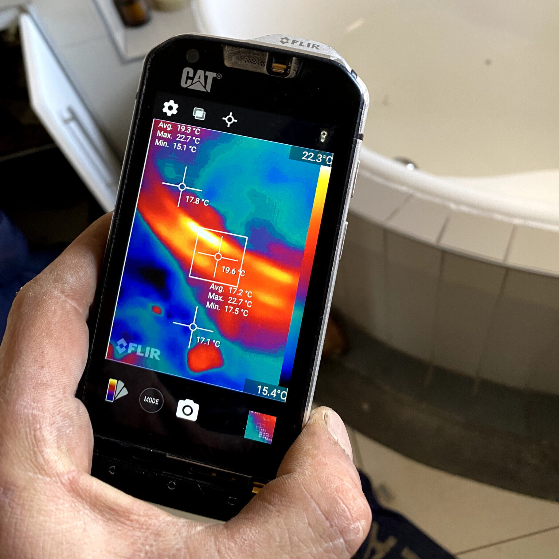 A thermal camera being used to inspect the outside of a bath for a water leak.