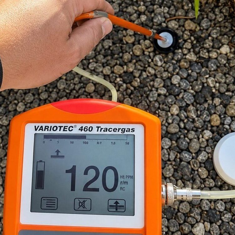 A residential tracer gas leak detection test conducted outdoors.