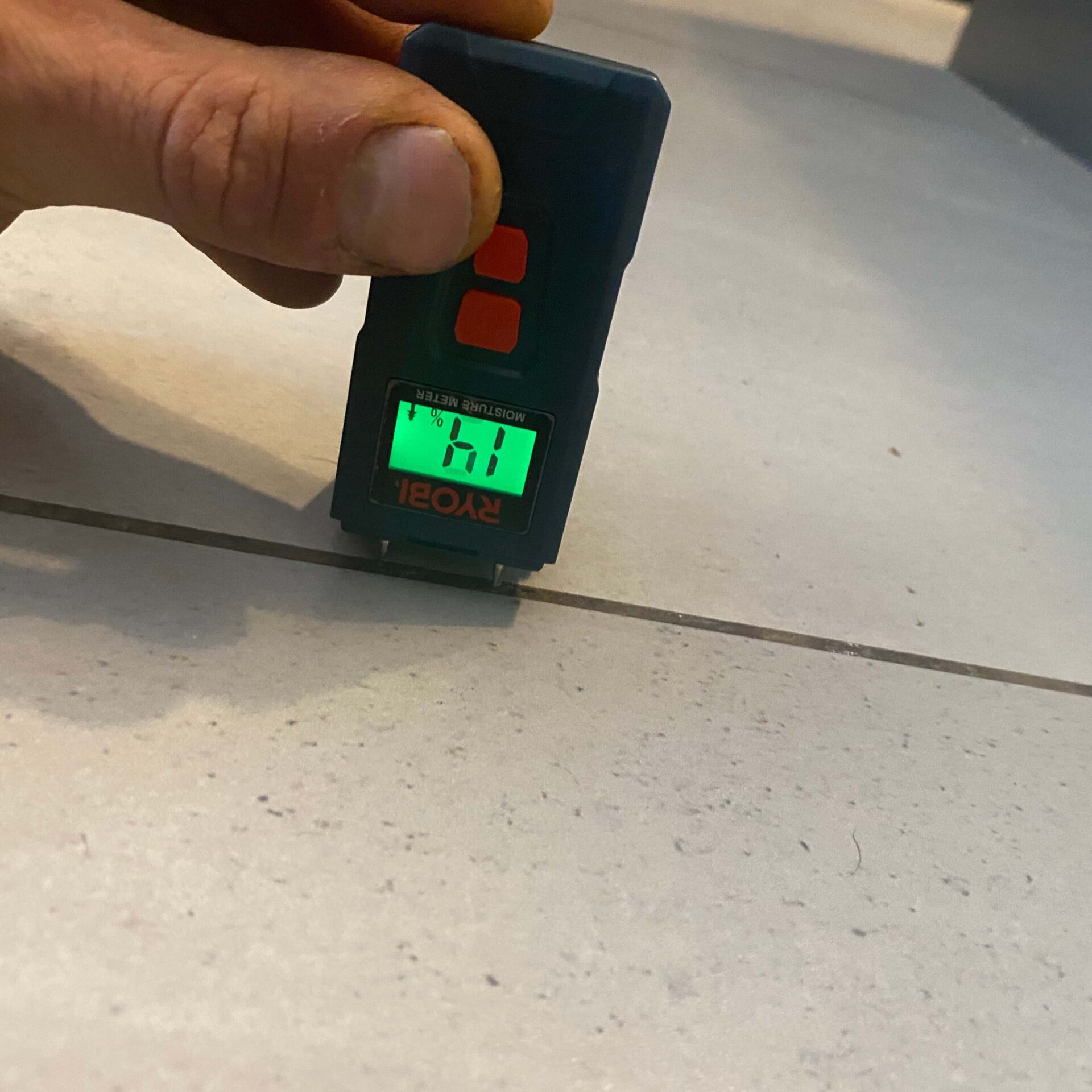 Image of a moisture sensor being used to detect moisture on tiles